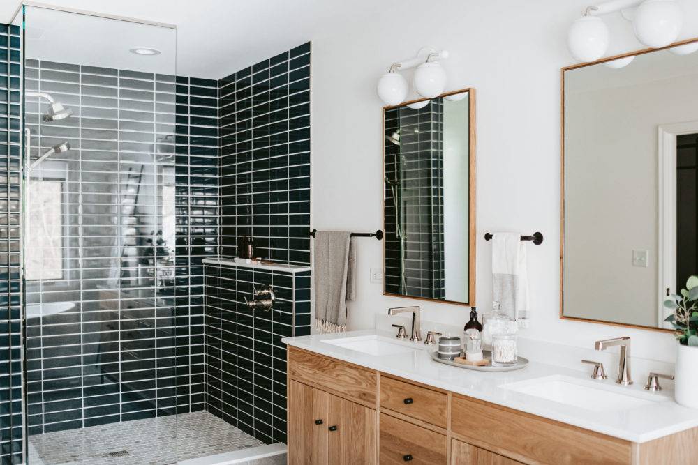 Modern bathroom with dark blue subway tile shower and wood vanity