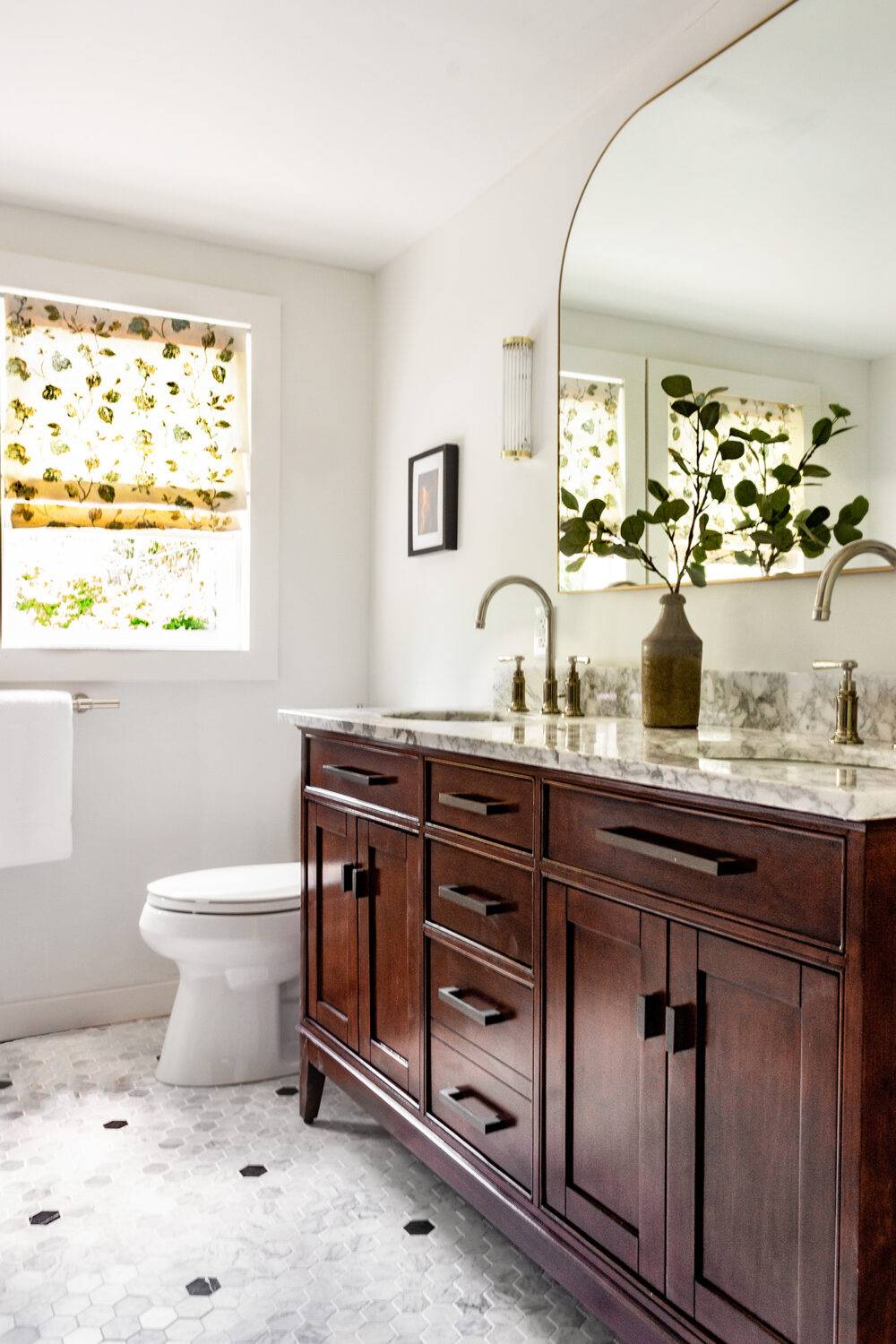 Bathroom with polka-dot black and white hexagon floor. 