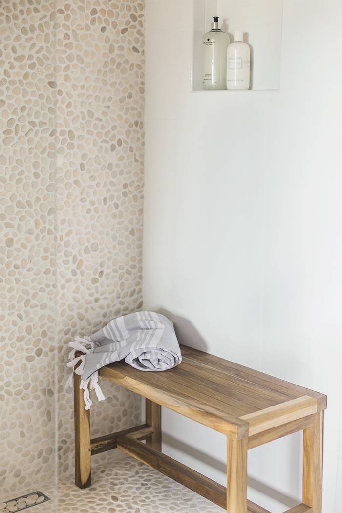 Small shower with grey pebble mosaic tile. 